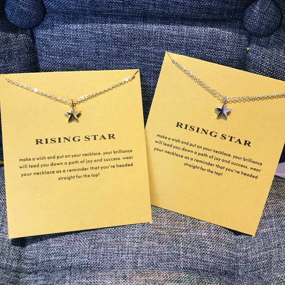 Collar colgante delicado de estrella en tono dorado sobre tarjeta amarilla con texto inspirador.