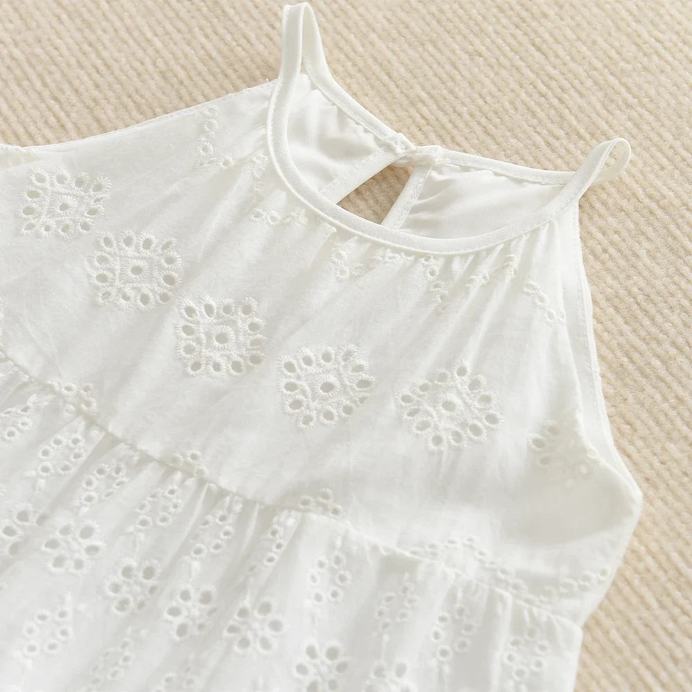 White cotton suspenders dress for a toddler girl with eyelet embroidery