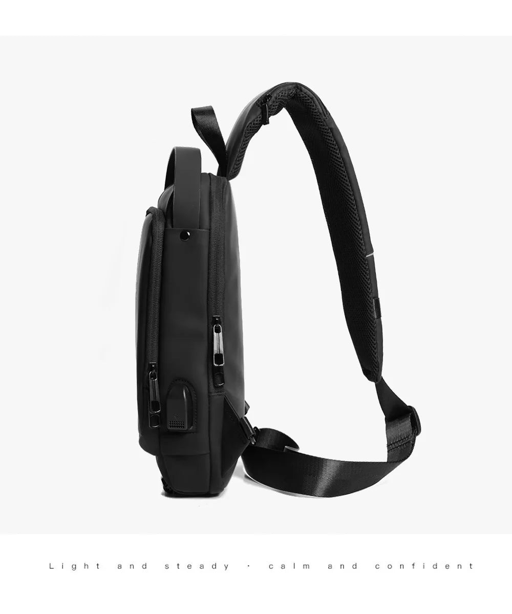 Bolso bandolera antirrobo para hombre, negro, con correa acolchada, sobre fondo blanco.