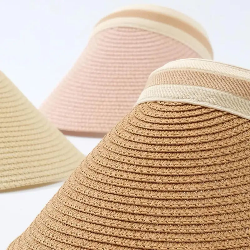 Close-up view of a woven straw sun hat in beige and tan colors.