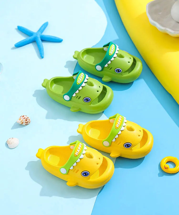 A collection of green and yellow kids shark clog sandals with anti-slip soles on a light blue background.