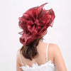 A close-up of a deep red ruffled organza sun hat with a wide brim and mesh detailing.