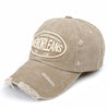 En vintage vasket bomuldsbaseballkasket i tan farve med en broderet cirkel, der siger New Orleans.