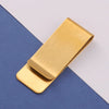 A gold metal tie clip lying on a dark blue and white background.