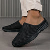 A pair of black breathable slide sandals with a non-slip EVA outsole shown on a person's foot.