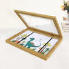 A wooden art display frame with a glass cover displaying a dinosaur and foliage design.