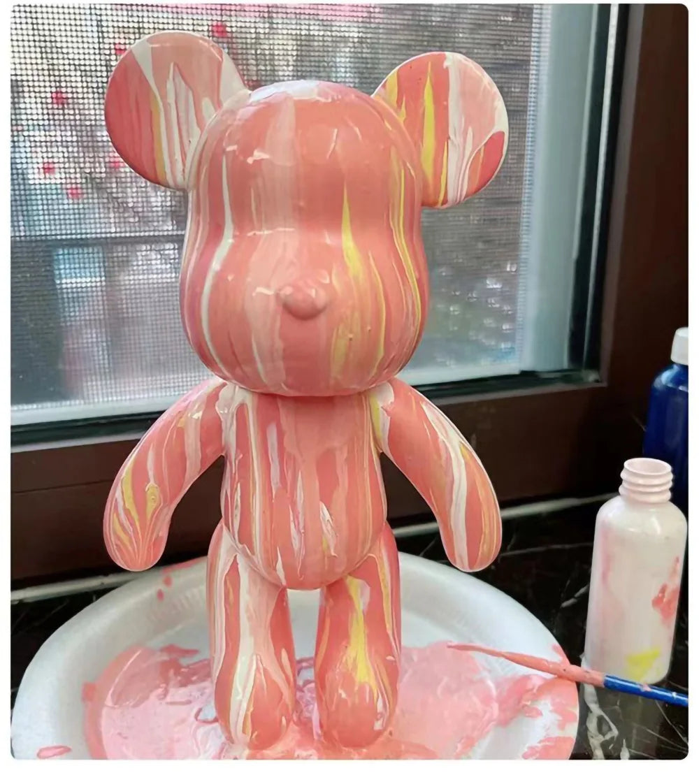A pink bear figurine painted with marbled orange and yellow stripes, standing in a white dish.