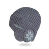 A gray knitted beanie with earflaps shown from above.