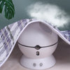 A white waterproof baby mattress protector with a cute cartoon design is shown, partially covered by a plaid cloth.