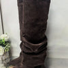A pair of dark brown velvet knee-high boots with chunky heels and a metal buckle.