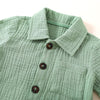 A light sage green linen shirt with a collar and button placket, shown flat lay.