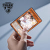 Una mano sostiene una funda de cartas Magic con cráneo de tiburón e ilustración de Ash Blossom & Joyous Sp