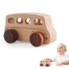 A light wood hand-pushed wooden cart toy for toddlers with round wheels and clear windows, being held by a baby.