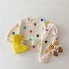 A cream-colored kids cotton hooded sweater and pants set with colorful polka dots