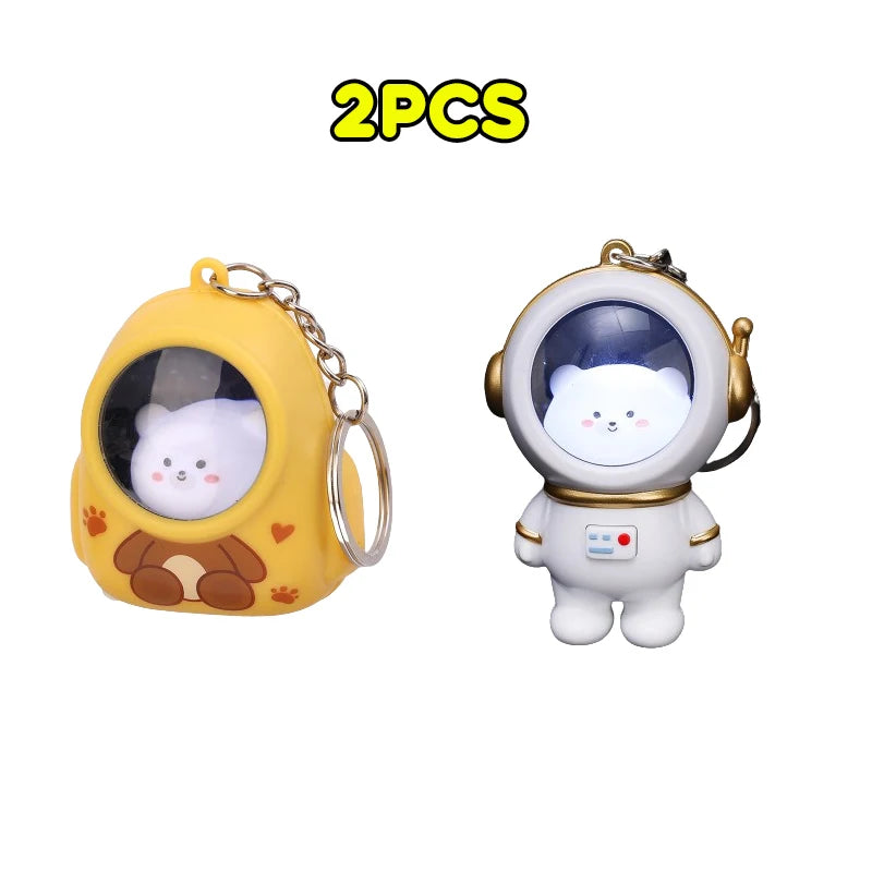 Two yellow bear-shaped nightlight keychains with astronaut charms
