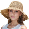 A woman wearing a beige woven sun visor hat with gold glitter trim and lace details.