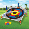 Portable cornhole toss game set featuring a large board with colored targets and six bean bags on a green lawn.