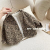 A leopard print denim jacket is displayed on a hanger against a light background.