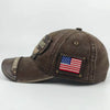 A dark brown vintage washed baseball cap featuring an embroidered letter patch and a patriotic flag patch.