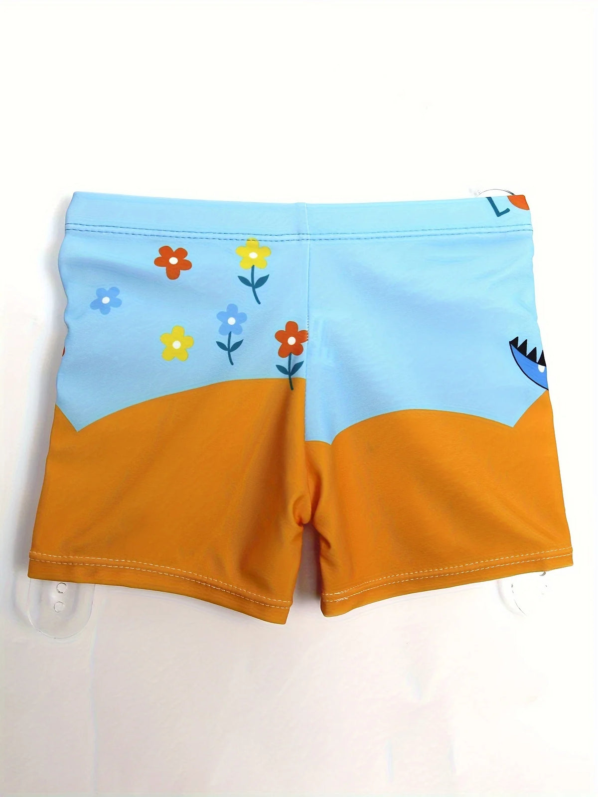Light blue swim trunks for boys featuring a floral pattern and an orange lower section.