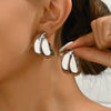Silver double-layer hollow flower hoop earrings being worn by a woman