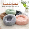 A collection of round plush pet beds in various colors including green, gray, and pink, used as winter bed pads for dogs and 