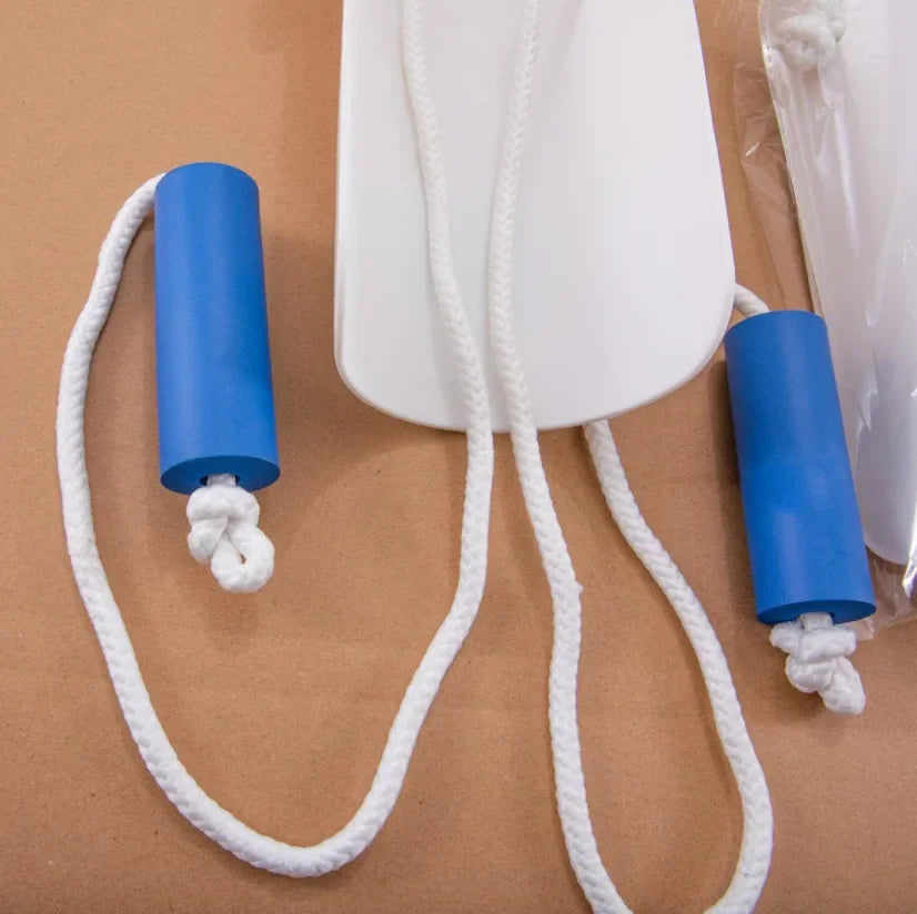 A blue sock aid with a white cord is shown next to a clear plastic bag on brown paper.