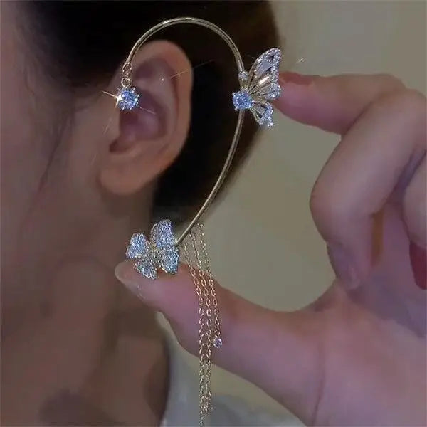 Gold ear cuff with a butterfly design and a dangling gold tassel