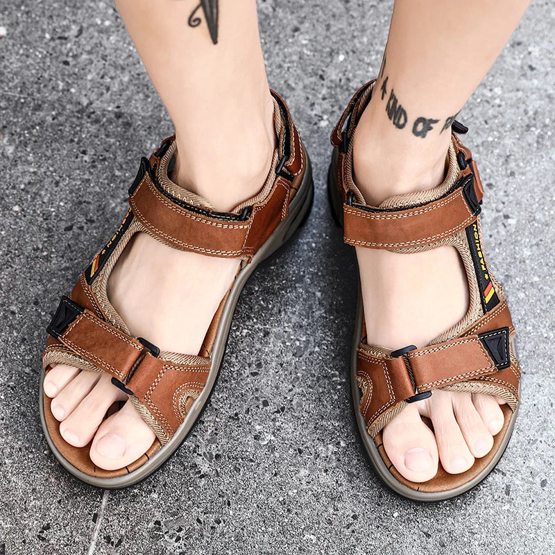 Pair of brown men's genuine leather air cushion sandals worn on a gray pavement.