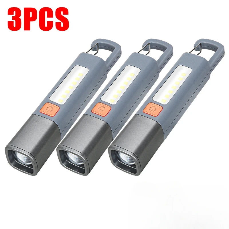 Three compact gray LED flashlights with hooks shown side by side.