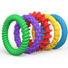 A set of five textured sensory fidget rings in green, purple, red, yellow, and blue.