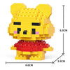 A yellow micro building block figurine of a bear with a red outfit and black facial features.