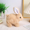 A light brown plush bunny toy with white inner ears sitting on a white surface.