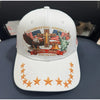 White baseball cap featuring a patriotic graphic design with an eagle, a cross, and a liberty statue.