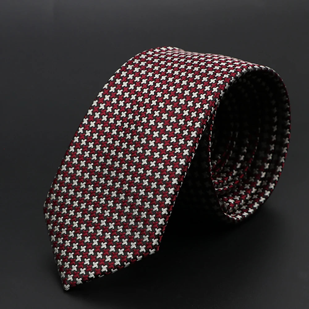 Corbata jacquard slim fit para hombre, diseño estampado en rojo oscuro y blanco, enrollada.