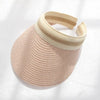 A woven straw sun hat in a light pink color with a beige band for women.