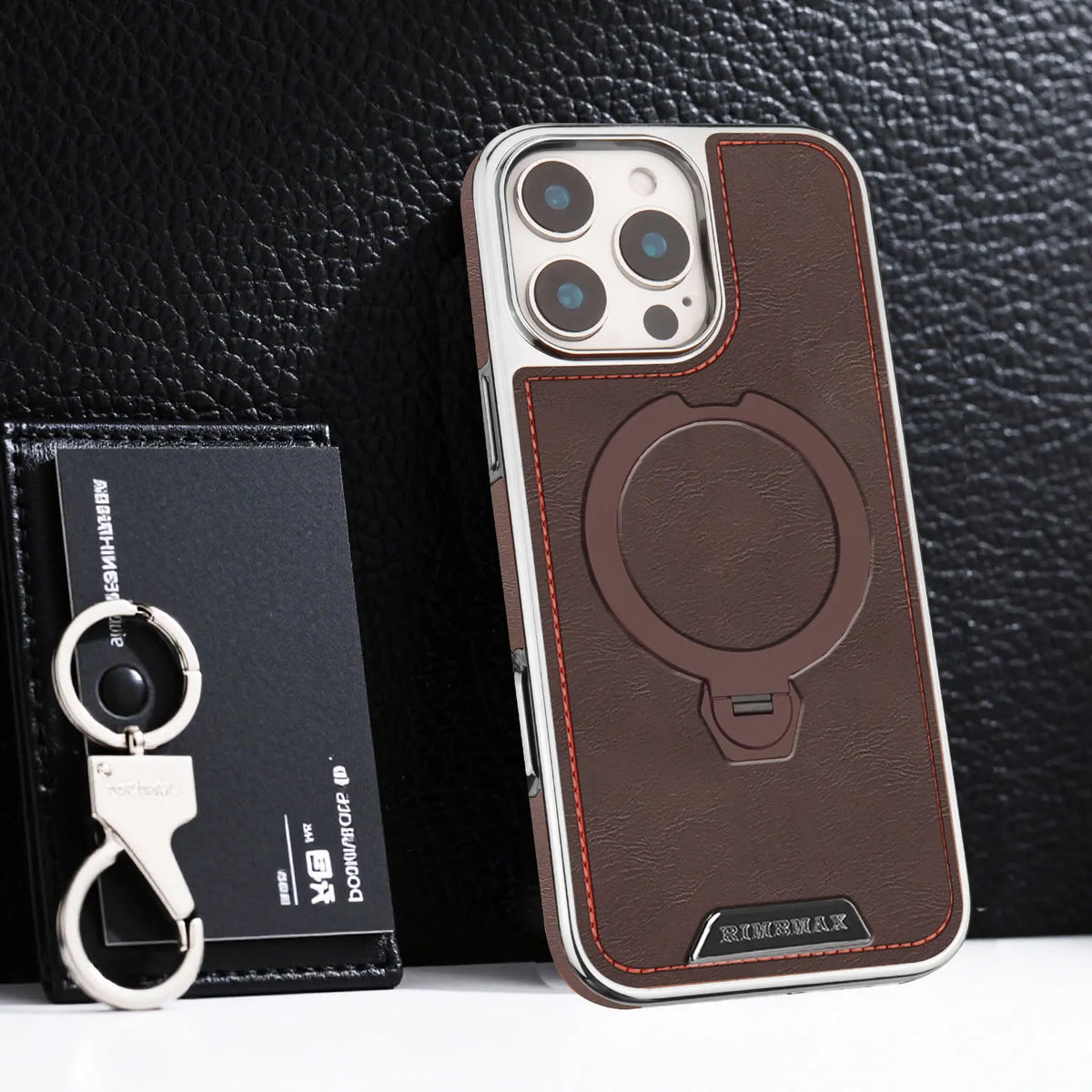 A brown leather case with a magnetic stand for an iPhone is shown next to a black magnetic lanyards.