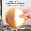 A hand is pouring detergent onto a yellow double-sided non-stick dish sponge for cleaning.