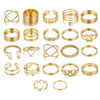 A collection of gold rings featuring various designs including hearts, geometric shapes, crosses, and butterfly motifs.