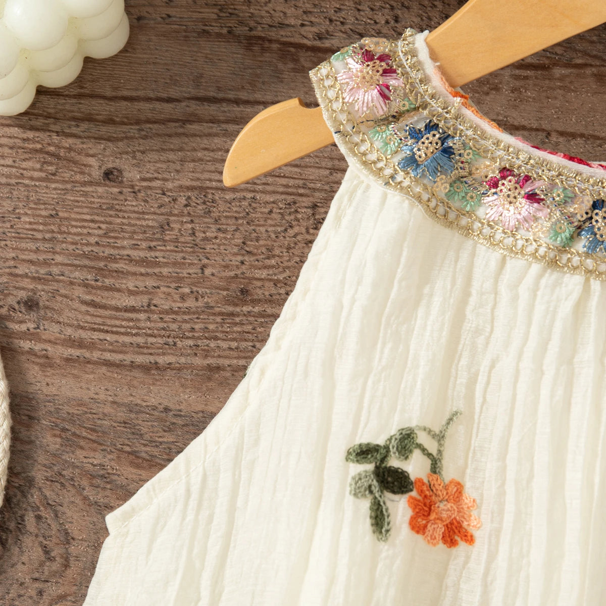 White sleeveless dress for baby girls with floral embroidery on the neckline