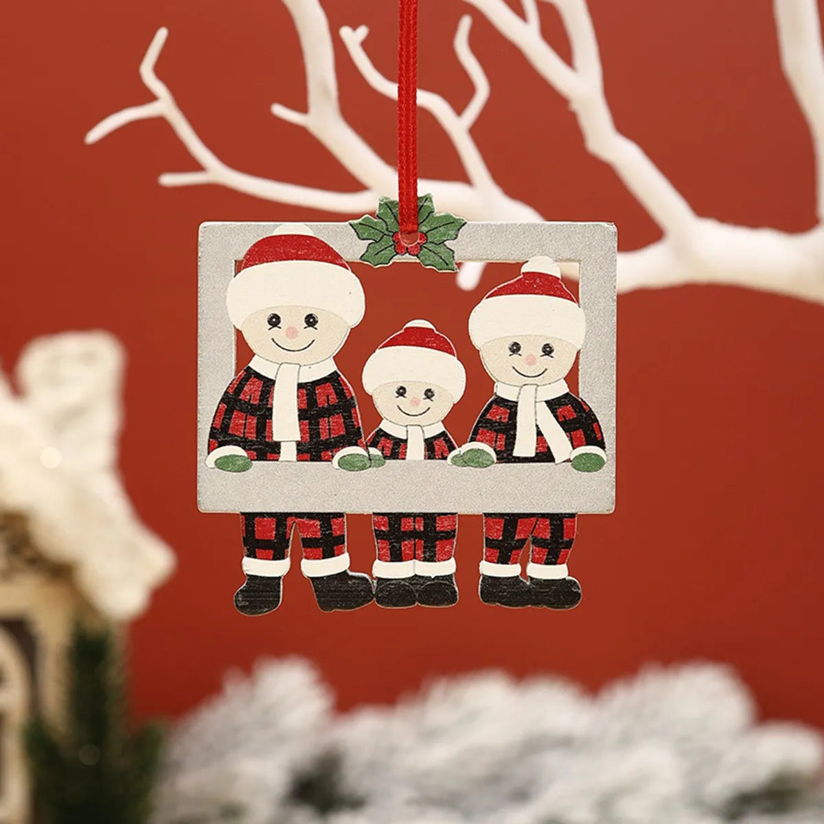 Personlig familiepynt til juletreet med bilde av to figurer i juleantrekk.