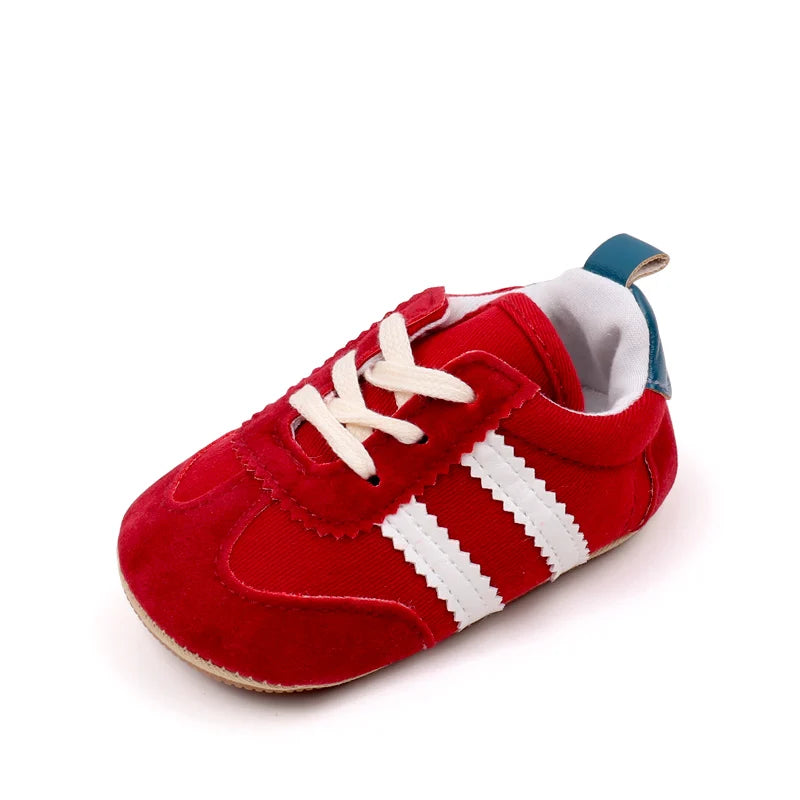 A pair of red baby first walker shoes with white stripes and a light blue lining.