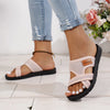 A close-up of women's pink breathable mesh flat sandals with a black sole and tan accents worn on a foot.