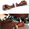 A pair of brown car seat headrest hooks with green accents used for hidden storage organization.
