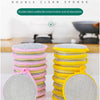 A stack of double-sided cleaning sponges in pink and yellow colors are shown on a white surface.