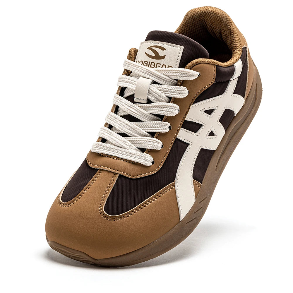 Seitenansicht eines braun-schwarzen minimalistischen Sneakers mit weißen Schnürsenkeln und einem 'S'-Logo.