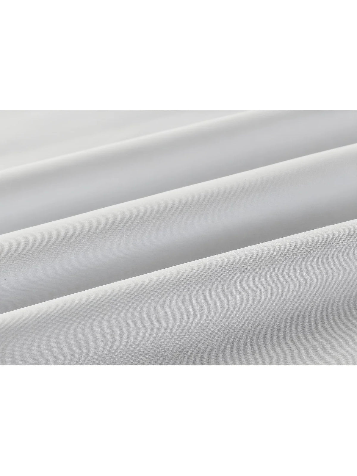 A close-up of a white long-sleeve formal shirt fabric draped and folded.