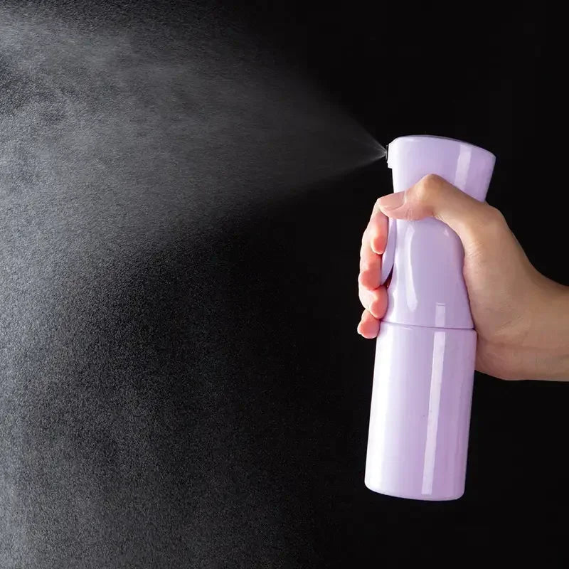 Una mano rocía una superficie oscura y texturizada con un atomizador morado.