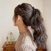 Perfil de mujer con peinado trenzado y suéter beige de punto