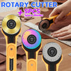 A hand is holding a yellow rotary cutter with a black handle and a blade, next to spare blades and a ruler.